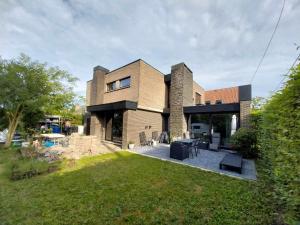 a brick house with a patio and a yard at Apartment in Vichte 1 Bedroom in Anzegem
