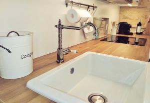 a white sink in a kitchen next to a bucket at Gîte du Moulin de Maître Pierre in Payrignac
