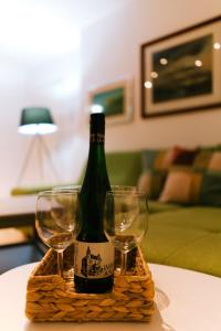 a bottle of wine and two glasses on a table at Holiday Home Green House in Divčibare