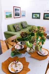 a table with plates and potted plants on it at Holiday Home Green House in Divčibare +78 photos