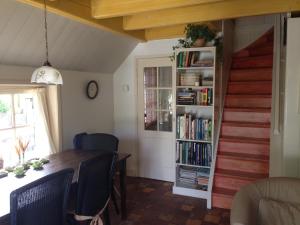 a dining room with a table and a book shelf at Dune Bep in Schiermonnikoog