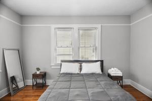 a bedroom with a large bed with two windows at 1936 Bungalow - Olde Town Southern Charm in Augusta