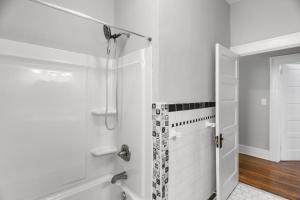 a white bathroom with a shower and a tub at 1936 Bungalow - Olde Town Southern Charm in Augusta +15 photos
