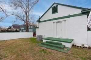 a white house with a green bench in the yard at 1936 Bungalow - Olde Town Southern Charm in Augusta