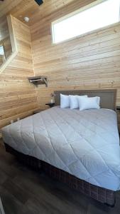 a bedroom with a large bed in a wooden wall at 064A Brand New Peaceful Chalet with Loft & King Bed near Grand Canyon South Rim in Valle