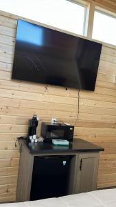 a large flat screen tv hanging on a wall at 060A Brand New Cozy Cabin with Loft & King bed near Grand Canyon South Rim in Valle +14 photos