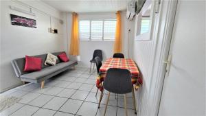 un piccolo soggiorno con tavolo e divano di Suite familiale 4 personnes chez l'habitant - Sports & aéroport à proximité a Le Lamentin
