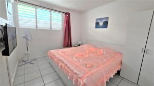 una camera con letto e finestra con ventilatore di Suite familiale 4 personnes chez l'habitant - Sports & aéroport à proximité a Le Lamentin