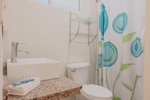 Un baño con inodoro y cortina de ducha. en Hotel Windsor Plaza, en San Salvador