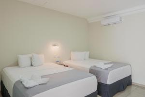 Dos camas en una habitación con paredes blancas. en Hotel Windsor Plaza, en San Salvador