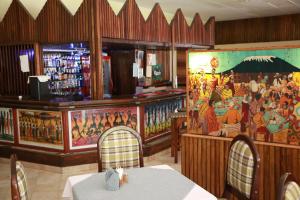 a restaurant with a large painting on the wall at Equator Hotel in Arusha