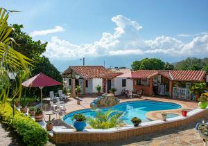 a villa with a swimming pool and a house at Mi Terruño in Barichara