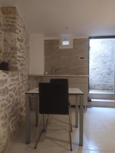 a kitchen with a table and a black chair at Le segrete in Sannicandro di Bari