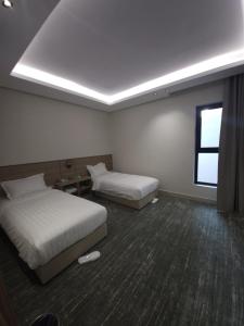 a hotel room with two beds and a window at فيلا هيفاء in Al Madinah
