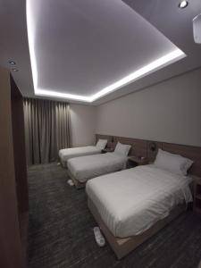a hotel room with three beds and a ceiling at فيلا هيفاء in Medina