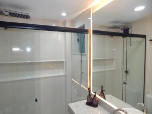 une salle de bain avec une douche en verre et un lavabo dans l'établissement Lindo e luxuoso apto no coração de Copacabana, à Rio de Janeiro 27 autres photos