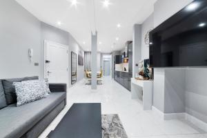 een woonkamer met een bank en een keuken bij High Ceiling Modern Apartment Heart of Central London in Londen
