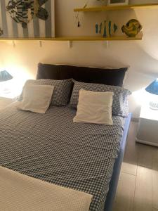 a bed with two pillows on it in a room at Appartamento vista mare Capo Falcone in Stintino