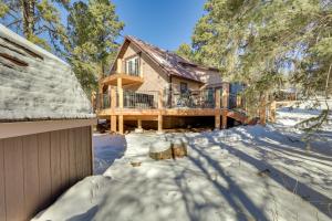 a house in the snow with a roof at Cozy Lead Cabin with Deck Less Than 1 Mi to Ski Slopes! in Lead