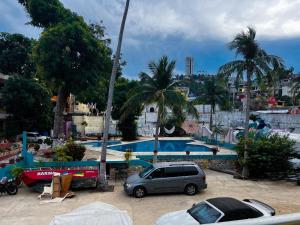 a car parked in front of a swimming pool at Hotel Walton in Acapulco