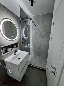 a bathroom with a white sink and a shower at RONApartament in Bacău