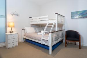 a bedroom with a white bunk bed with a ladder at C-Scape water front apartment in Cowes +22 photos
