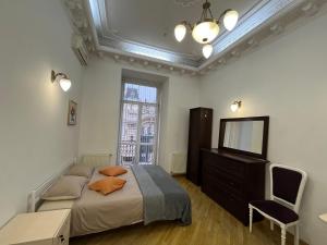 a bedroom with a bed and a dresser and a television at Центрум Апартаментс in Lviv