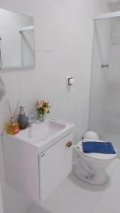 a white bathroom with a toilet and a sink at Chalé Da Bia in Cananéia +94 photos