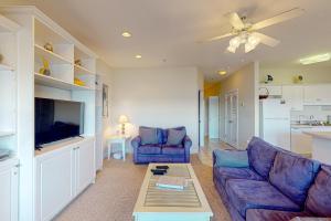 a living room with a couch and a tv at Peace on the sound, fun on the Beach in Indian Beach