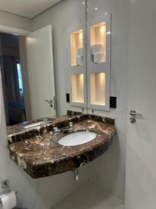 a bathroom with a marble sink and a mirror at Residencial Luxo Moema - Macuco in Sao Paulo