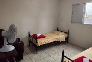 a small bedroom with a bed and a fan at Sobrado a Beira Mar in Rio Grande +8 photos
