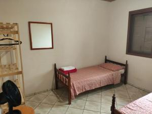 a small bedroom with a bed and a mirror at Sobrado a Beira Mar in Rio Grande