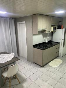 una cocina con estufa y encimera en Green House, en Pontal do Paraná