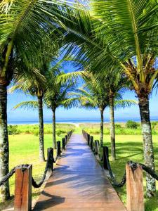 Un camino de madera con palmeras en una playa. en Green House, en Pontal do Paraná 8 fotos más