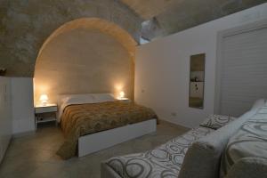 マテーラにあるIl Nespolo Materaのベッドルーム1室(ベッド2台付)、アーチ型の間取り