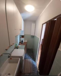 a small bathroom with three sinks and a mirror at Appartamento immerso nel verde vista panoramica in Pragelato