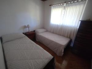 two beds in a small bedroom with a window at Las palmeras in Villa Lía +11 photos