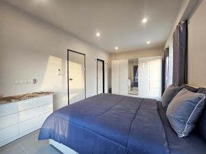 a bedroom with a blue bed and a mirror at Sirihouse at Supalai Bella Thalang Phuket in Phuket