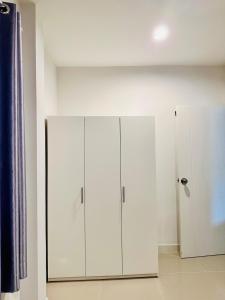 a room with two white cabinets and a wall at Sirihouse at Supalai Bella Thalang Phuket in Phuket +57 photos