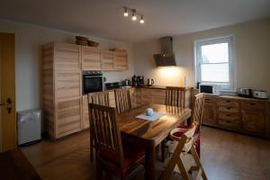 a kitchen with a wooden table and wooden cabinets at HarzHub Braunlage in Braunlage