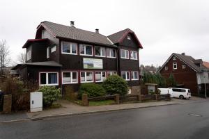 a black house with a white van parked in front of it at HarzHub Braunlage in Braunlage
