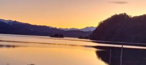 a view of a body of water at sunset at Monoambiente Neli in Villa Pehuenia +5 photos