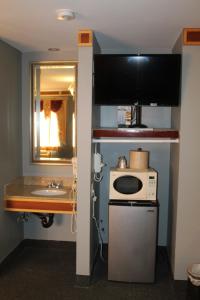 a small kitchen with a sink and a microwave at Liberty Inn Absecon Atlantic City in Galloway +27 photos