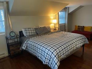 a bedroom with a bed with a checkered blanket at Swing Bridge Cottage on Lake Simcoe - Waterfront in Brechin