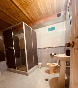 a bathroom with a shower and a toilet and a sink at Leño Verde in Espinal