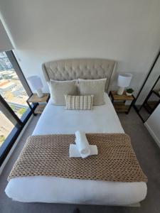 布里斯班Luxury Peppers Infinity Pool Stylish with 2BD & 1C Park的一间卧室配有一张大床,上面有毛巾 更多18张照片