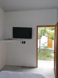 a bedroom with a flat screen tv on a white wall at Casa del Cable in Mariquita