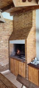 a brick fireplace with a fire in it at Cassara Retreat in La Consulta