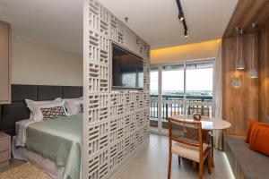 a bedroom with a bed and a table in a room at Flat Premium - Capital Brasília Flats in Brasilia