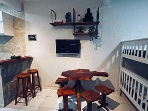 een kamer met een bar met krukken en een tv bij Meu Loft Barra Nova 2 in Saquarema